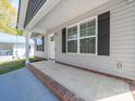 Covered front porch with brick accents and gray siding for added curb appeal at 423 Pleasant Ave, Kannapolis, NC 28081