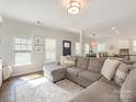 Cozy living space featuring a large sectional sofa, hardwood floors, and ample natural light at 4303 Patriots Hill Rd, Mint Hill, NC 28227