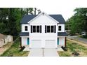 Wide view of a modern home with black roof, white siding, and two-car garages at 615 Billingsley Rd, Charlotte, NC 28211