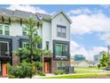 Townhome exterior showcasing modern design, brick accents, and vibrant orange front door framed by green landscaping at 648 W End Dr, Charlotte, NC 28208