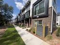 Row of modern townhomes showing sidewalks, manicured lawn, brick accents, and small balconies at 648 W End Dr, Charlotte, NC 28208