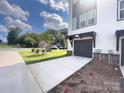 Townhome featuring a one-car garage, driveway, and well-manicured front yard at 648 W End Dr, Charlotte, NC 28208