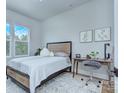 Cozy bedroom featuring a striped bedspread, a wooden desk, and bright natural lighting through large windows at 7005 W Duncan Rd, Indian Trail, NC 28079