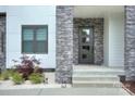 Modern entrance with stone details, a contemporary front door, and manicured landscaping at 7005 W Duncan Rd, Indian Trail, NC 28079