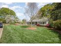 Well-maintained single-story home featuring a lush green lawn and beautiful, colorful landscaping at 726 Grandview Ne Dr, Concord, NC 28025