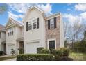 Inviting townhome exterior featuring a garage, brick accents, and tidy landscaping at 7445 Abigail Glen Dr, Charlotte, NC 28212