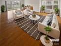 Bright living room featuring hardwood floors, modern furniture, and large windows offering plenty of natural light at 8929 Meadow Vista Rd, Charlotte, NC 28213