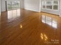 Spacious living room features hardwood floors and large windows, providing ample natural light and an airy feel at 8929 Meadow Vista Rd, Charlotte, NC 28213