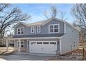 Inviting two-story home features gray siding, a two-car garage, and classic architectural details at 1034 Dooley Dr, Charlotte, NC 28227