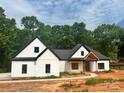 New construction featuring a white exterior, black trim, and a covered porch with a wood beam accent at 12069 Coyle Rd, Stanfield, NC 28163