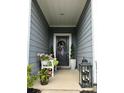 Inviting front porch features a decorative wreath, potted plants, and a cozy bench, creating a welcoming entrance at 123 Grey Fox Ln, Mount Gilead, NC 27306