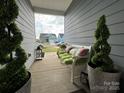 Cozy front porch view with bench seating and potted topiaries, offering a glimpse of the neighborhood at 123 Grey Fox Ln, Mount Gilead, NC 27306