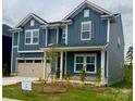 Two-story home showcases a blue exterior, a two-car garage and a well-manicured front lawn at 13737 Roderick Dr # 186, Huntersville, NC 28078