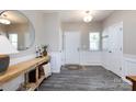 Elegant foyer features wood-look flooring, wainscoting, console table with decor, and a round mirror at 325 Crandon Rd, Mount Holly, NC 28120