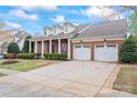 Traditional brick home featuring an attached three-car garage, dormer windows, and a covered porch at 331 Miners Cove Way, Fort Mill, SC 29708