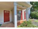 Inviting front porch with red door, white columns, and well-maintained landscaping at 3835 Mohawk Ct, Charlotte, NC 28215