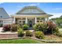 Inviting front exterior showcasing a landscaped yard and a covered porch with ceiling fans at 4006 Fall Oak Ter, Fort Mill, SC 29707