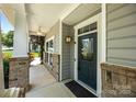 Close-up of the covered front porch featuring brick accents and stylish front door at 4006 Fall Oak Ter, Fort Mill, SC 29707