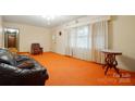 Inviting living room with orange carpet, a fireplace, and large windows at 422 Sherrill Farm Rd, Lincolnton, NC 28092
