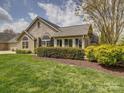 Landscaped yard complements this single-Gathering home, featuring stone accents and mature shrubbery at 4754 Polo Gate Blvd, Charlotte, NC 28216