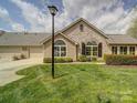 Charming home featuring stone accents, well-manicured lawn, and a two-car garage, creating an inviting curb appeal at 4754 Polo Gate Blvd, Charlotte, NC 28216