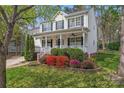 Inviting two-story home with a classic porch, complemented by colorful landscaping and mature trees at 5225 Mcchesney Dr, Charlotte, NC 28269