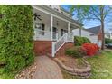 Charming front porch with brick accents, leading to a beautifully landscaped yard at 5225 Mcchesney Dr, Charlotte, NC 28269