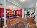 Elegant dining room featuring rich red walls, hardwood floors, and stylish chandelier at 615 Reliance Ct, Tega Cay, SC 29708