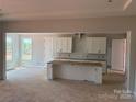 Bright kitchen features white cabinets, center island, and plenty of natural light at 6707 Baker Creek Ave, Indian Land, SC 29707