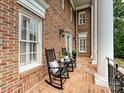 Cozy front porch featuring comfortable seating, classic brickwork, and elegant architectural details at 8623 Tullamore Park Cir, Charlotte, NC 28226