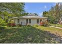 This home is surrounded by lush greenery, vibrant flowers, and a well-maintained lawn on a sunny day at 8974, 8972 & 8970 Nc 90 E Hwy, Stony Point, NC 28678