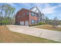 Spacious driveway leading to a three-car garage with a beautiful lawn at 9032 Cornflower Dr, Harrisburg, NC 28075