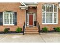Charming front entrance with red brick facade, symmetrical windows, and inviting front door at 10609 Washam Potts Rd, Cornelius, NC 28031