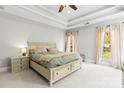 Bright main bedroom with tray ceiling, neutral decor, large bed, and plenty of natural light at 10609 Washam Potts Rd, Cornelius, NC 28031