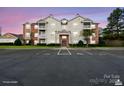 Residential condo building with a parking lot, a manicured lawn and an attractive sunset at 10720 Hill Point Ct, Charlotte, NC 28262