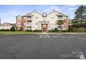 Exterior of a residential condo building showing a parking lot and manicured lawn at 10720 Hill Point Ct, Charlotte, NC 28262