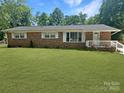 Charming single-story brick home featuring a well-manicured lawn and a cozy, white-railed front porch at 1121 Rembrandt Sw Dr, Concord, NC 28027