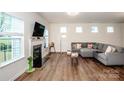 Comfortable living room featuring a fireplace, gray sectional, and hardwood flooring for a cozy ambiance at 123 Abersham Dr, Mooresville, NC 28115