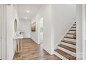 Welcoming hallway with hardwood floors, leading to the staircase and other areas of the home at 13756 Roderick Dr # 176, Huntersville, NC 28078