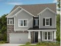 Charming two-story home with a mix of stone and gray siding, and a covered front porch at 1471 Hubert Graham Way, Tega Cay, SC 29708