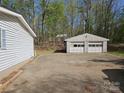 Detached two-car garage with concrete driveway and mature trees at 1586 Brook Ln, Denver, NC 28037