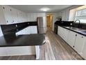 Modern kitchen featuring white cabinets, dark countertops, stainless steel appliances, and wood floors at 1628 B Se Ave, Hickory, NC 28602