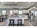 Bright kitchen with white cabinetry, stainless steel appliances, granite counters, and island seating for two at 169 Basildon St # 1012, Lancaster, SC 29720