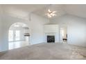 Bright living room featuring a fireplace, neutral carpet, and an arched doorway leading to the kitchen at 1805 Lawton Dr, Rock Hill, SC 29730