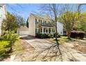 Traditional two-story home with a detached garage, complemented by mature trees and a green lawn at 18838 Oakhurst Blvd, Cornelius, NC 28031