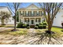 Inviting two-story home with a covered front porch, green shutters, and manicured landscaping at 18838 Oakhurst Blvd, Cornelius, NC 28031