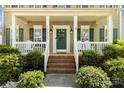 Inviting front porch with classic details, white railings, and a decorative wreath on the front door at 18838 Oakhurst Blvd, Cornelius, NC 28031