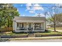 Inviting single-story home with a classic porch featuring a cozy seating area and beautiful landscaping at 207 Kerr Nw St, Concord, NC 28025