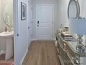 Inviting entryway features wood-look floors, console table, and convenient pedestal sink powder room at 314 Olympia Way, York, SC 29745