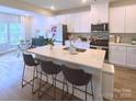 Modern kitchen features a large island with barstool seating and bright white cabinetry at 314 Olympia Way, York, SC 29745